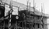 In 1936, construction of the Kaserne is fully underway. To honor the workers, visiting military dignitaries speak to the tradesmen from a temporary platform in front of the building which would, 36 years later, be the 2/11 dining facility. In 1936, construction of the Kaserne is fully underway. To honor the workers, visiting military dignitaries speak to the tradesmen from a temporary platform in front of the building which would, 36 years later, be the 2/11 dining facility.